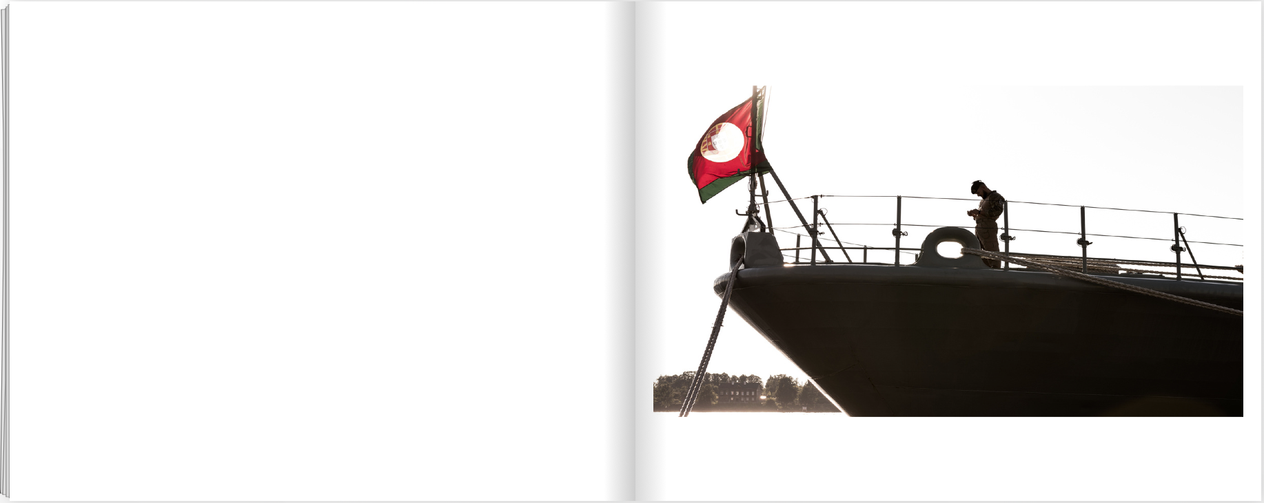 Dupla página com a proa de um navio militar, a bandeira portuguesa e uma pessoa junto à amurada, recortadas contra um céu claro.